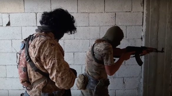 Снимок экрана с видеоролика показывает, как кыргызские боевики совершают налет на здание в Алеппо в 2016 году.