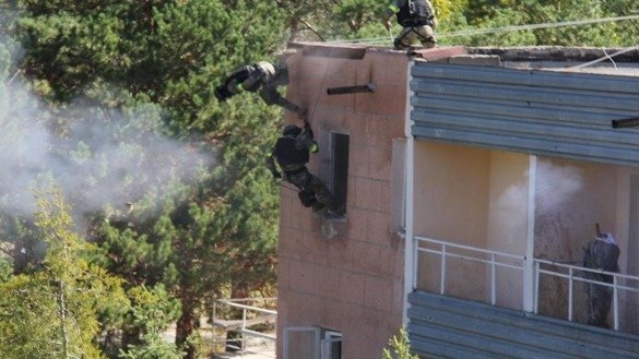 Troops storm a building during Issyk-Kul Anti-Terror 2017. "During the exercises, officers and enlisted personnel checked the efficiency of arrangements for alerting the public during the type of crisis that arises when terrorists seize hostages or strategic facilities," said GKNB official Rakhmat Sulaimanov. [Kyrgyz State National Security Committee]