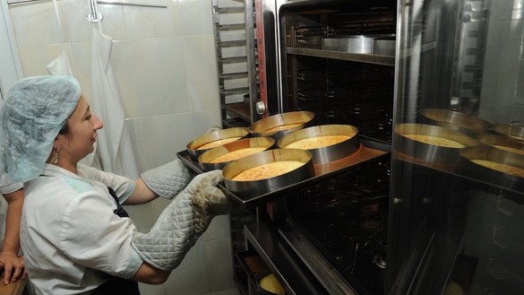 Асмар пишириқлар дўконида новвой печдан пишириқларни олмоқда, октябрь, Алмати. Пишириқлар дўкони Асел Баялинова очган ва эгалик қилган муассасалардан бири. Европа тикланиш ва тараққиёт банкига (ЕТТБ) кўра, Қозоғистонда аёллар мамлакатдаги кичик ва ўрта бизнес корхоналарининг қарийб ярмига эгалик қиладилар ёки уларни бошқарадилар. (Владимир Третяков)