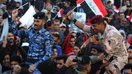 Ироқлик аскар ва полициячи Бағдоднинг Таҳрир майдонида ўз миллий байроғини кўтариб, ИШИД билан уч йил давом этган урушдан сўнг эришилган ғалабани нишонламоқда, 10-декабрь. (Аҳмад Ал-Рубае/AFP)
