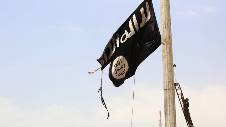 AQSH qo‘llab-quvvatlovidagi Suriya Demokratik Kuchlari (SDK) a‘zosi Suriyaning Tabqa shahrida ISHID bayrog‘ini olib tashlamoqda. Aprel, Suriya Demokratik Kuchlarining ISHID poytaxtiga aylangan Raqqa shahriga yurishidan avval. (Delil Souleiman/AFP)