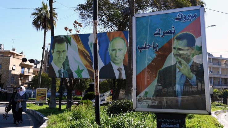 17 март куни олинган суратда Россия президенти Владимир Путин ва Сурия президенти Башар Асаднинг Алеппо шаҳридаги портретлари тасвирланган. (Жорж Урфалян/AFP)
