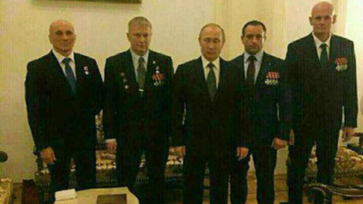 Россия президенти Владимир Путин (марказда) Wagner хусусий ҳарбий компаниясининг Дмитрий Уткин (ўнгдан охиргиси) ва бошқа қўмондонлари билан суратга тушмоқда. Ушбу фотосурат 2016 йил декабрь ойида олинган деб тахмин қилинади. (Файл)