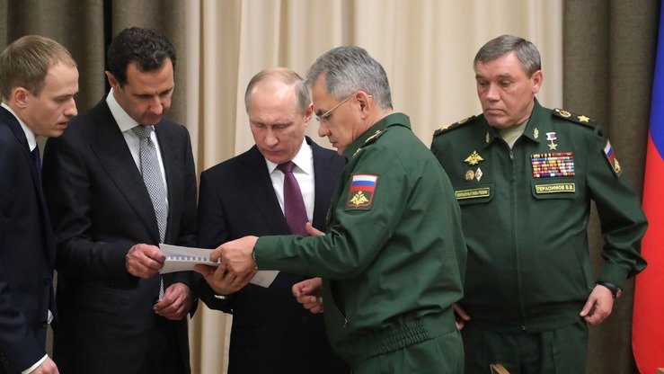 Ўтган йили 20 ноябрь куни Россия президенти Владимир Путин (марказда), Сурия президенти Башар Асад (чапдан иккинчи), Россия мудофаа вазирлиги ва Россия армиясининг бош штабининг юқори лавозимли расмийлари билан учрашди. (Кремль)