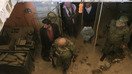 Rossiya askarlari 16-aprel kuni Dumaga uyushtirilgan media-tur davomida tashlandiq qurol-yarog‘ omborini ko‘zdan kechirmoqda. Media-tur Suriya hukumati tomonidan tashkillashtirildi, avvalroq Suriya armiyasi isyonchilar egallagan shaharga ikki oy davom etgan shiddatli hujumlardan so‘ng, barcha muxolif kuchlar Sharqiy G‘utani tark etganini e’lon qilgandi. (Luay Beshara/AFP)