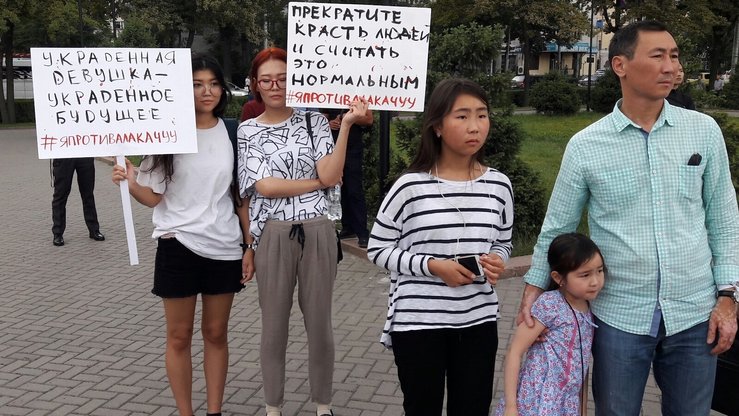 9-iyun kuni bishkekliklar kelin o‘girlash odatiga qarshi namoyishga qo‘shildilar. “Kelin o‘girlashga qarshiman” xeshtegi ostidagi bu ayol bannerida “Qiz o‘g‘irlash uning kelajagini o‘g‘irlash demakdir” va “Odam o‘g‘irlashni va buni oddiy holatni deb bilishni bas qiling” deb yozilgan. (Asker Sultanov)