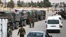 Rossiya askarlari Vafidin lageriga kiraverishda 12-aprel kuni Sharqiy G‘utaning Duma shahridan ko‘chirilgan Jaish al-Islom jangarilari va ularning oila a’zolari bo‘lgan avtobuslarning kelishini kutmoqdalar. (Yusuf Karvashan/AFP)