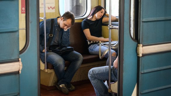Metroda uxlab ketayotgan yo‘lovchilar, Moskva, 2018-yil, 23-may. (Mladen Antonov / AFP)
