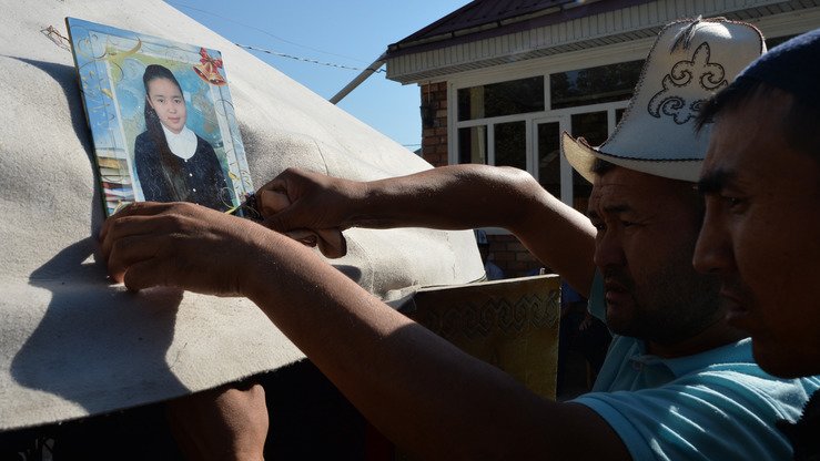 Burulay Turdaali Qizining qarindoshlari uning fotosuratini uyi yonida qurilgan o‘tov oldiga joylashtirmoqdalar, So‘quluq, 28-iyun. (Vyacheslav Oseledko/AFP)