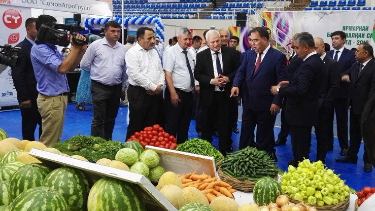 Сўғд вилояти ҳокими Ражаббой Аҳмадзода 2018 йил Сўғд халқаро савдо ярмаркасида тақдим этилган сабзавотларни кўрсатмоқда, Хўжанд, 6 июль. (Негматулло Мирсаидов)