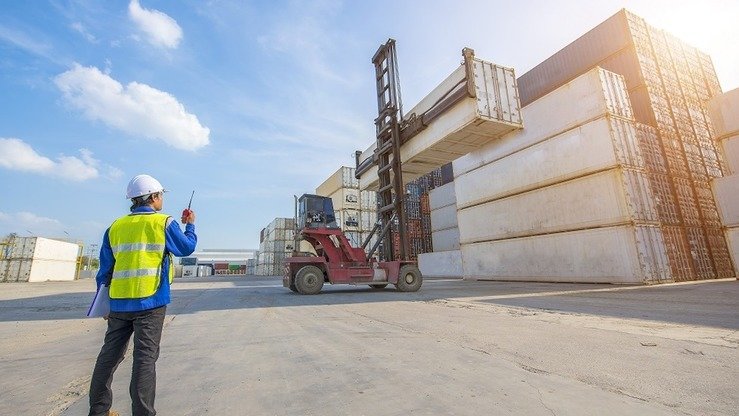 Ishchi Chimkent transport-logistika markazida konteynerlarning tashilishini kuzatmoqda, may oyida olingan surat. (Chimkent hokimiyati matbuot xizmati taqdim etgan surat)