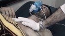 2017 йилнинг 4 апрель куни зарин гази билан тўлдирилган снарядлар ҳужумидан сўнг, Идлиб вилоятидаги мухолифат назоратида бўлган Хон Шайхун шаҳрида беморга ёрдам кўрсатилмоқда. Ҳужум 83 кишининг ҳаётига зомин бўлди. (Башир ал-Бассам тақдим этган сурат)
