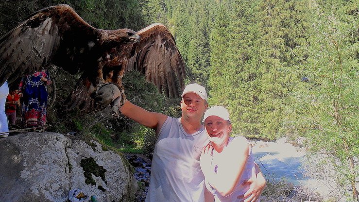 Qozog‘istonda sayyohlar yirtqich qushlar ovini tomosha qilishlari mumkin. Turistlar lochin bilan suratga tushmoqdalar, Jambul viloyati, 2018-yilning iyul oyi. (Aydar Ashimov)