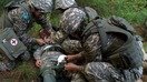 «Дашт бургути - 2018» машқлари давомида қозоғистонлик аскарлар «яраланган» шерикларини вертолётгача олиб бориш учун замбилга боғламоқда. (Аризона миллий гвардияси)