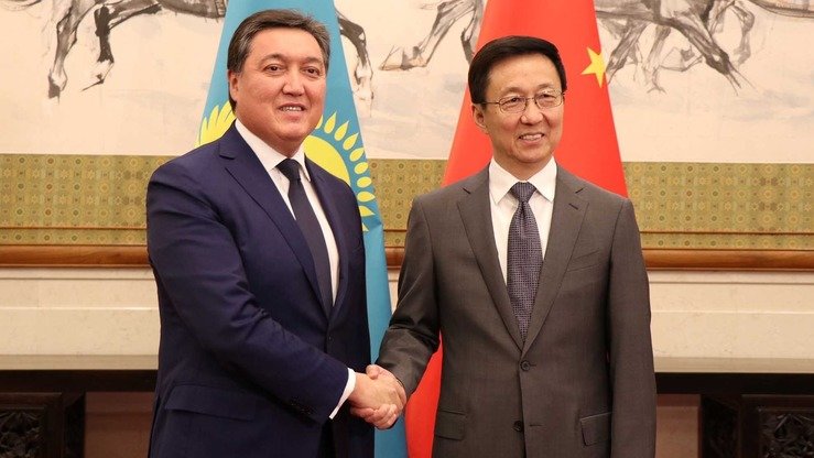 Қозоғистон бош вазири ўринбосари Асқар Мамин (чапда) 26 сентябрь куни Пекинда ХХР бош вазирининг биринчи ўринбосари Хан Чжен билан учрашди. (Қозоғистон ҳукумати матбуот хизмати)