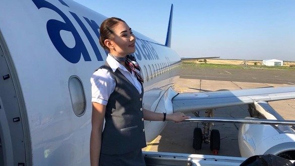 «Air Astana» стюардессаси йўловчиларни қарши олмоқда, август ойида олинган сурат. (Аir Astana)