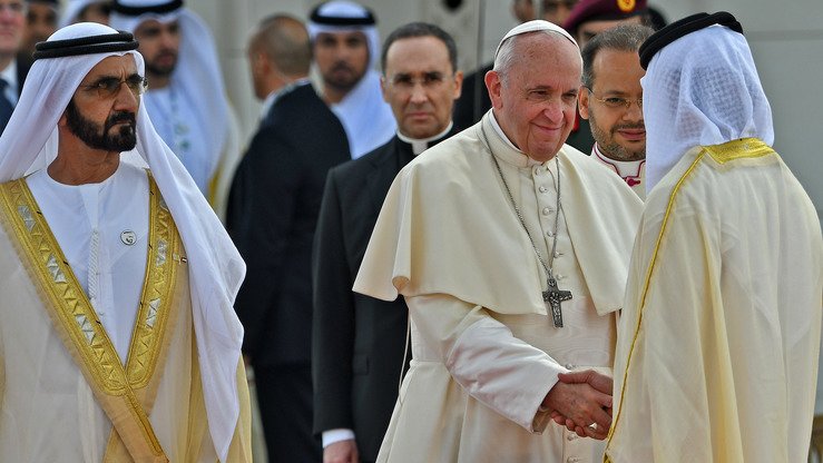 Rim papasi Fransisk Birlashgan Arab Amirliklari vitse-prezidenti va bosh vaziri shayx Muhammad bin Rashid Al Maktum hamrohligida mansabdor shaxslardan biri bilan qoʻl siqishmoqda, Abu Dabi, 4-fevral. (Vinchenzo Pinto/AFP)