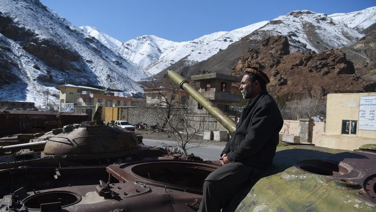 Shoʻrolar davridan qolgan tank qoldiqlari ustida o‘tirgan afg‘on, 7-fevral kuni Panjshir viloyati Bazarak tumanida olingan surat. (Vakil Koxsar/AFP)