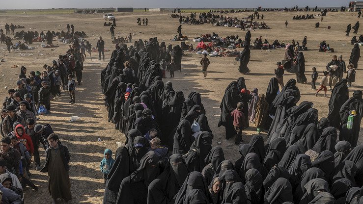 “Islom davlati”ning (ID) Bog‘uzdagi vayron bo‘lgan qo‘rg‘onidan qutqarilgan fuqarolar AQSH qo‘llovidagi kurdlar rahbarlik qiladigan Suriya demokratik kuchlariga (SDK) tegishli tekshiruv punktida navbatda turibdi. 5-mart kuni olingan surat. (Bulent Kilich/AFP)