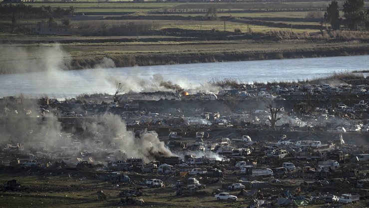Ifrot daryosining sharqiy qirg‘oqlaridagi ID qo‘rg‘onidan chiqayotgan tutun, 18-mart kuni olingan surat. (Delil Sulaymon/AFP)