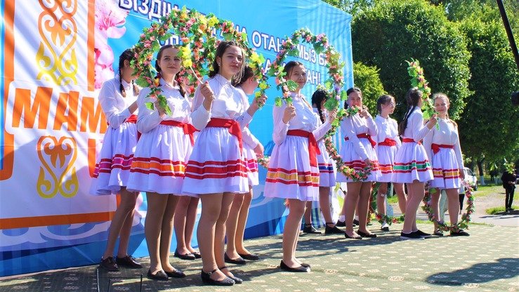 Халқ бирдамлиги кунига бағишланган чиқишлари олдидан саҳнада турган ўқувчи қизлар, Тараз, 1 май. (Айдар Ашимов)