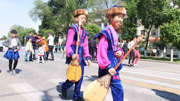 Мальчики идут по улице с национальным казахскими музыкальными инструментами 1 мая в Таразе в честь Дня единства народа Казахстана. [Айдар Ашимов]