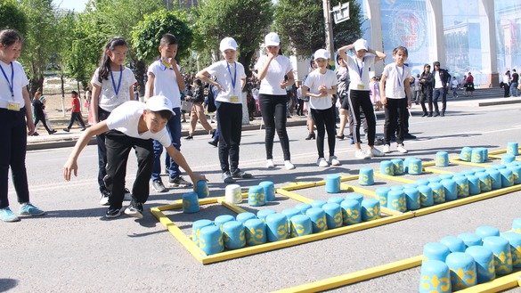 Мальчики и девочки играют в казахскую национальную игру 1 мая в Таразе. [Айдар Ашимов]