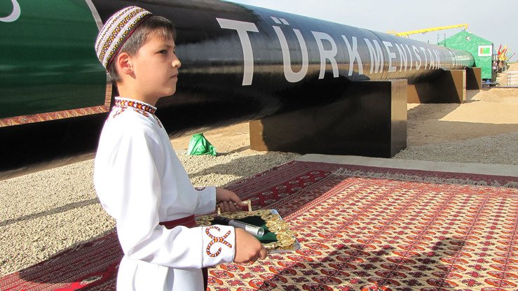 Туркманистонлик бола Шатлиқдаги Шарқий-ғарбий газ қувури линиясининг очилишига бағишланган расмий маросимда президент Гурбангули Бердимухамедовни кутмоқда, 2010 йил, 31 май. (AFP)