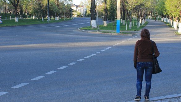 A woman crosses an empty street in Taraz on April 18. Residents must have a valid reason to leave home or face a fine. [Aydar Ashimov]