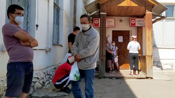 Relatives wait outside a hospital in Kara-Balta July 11 to bring food and medicine to patients. [Maksat Osmonaliyev]