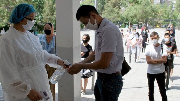 A young Kyrgyz taking the country's university entrance exam receives a dose of hand sanitiser July 13 in Bishkek. [Maksat Osmonaliyev]