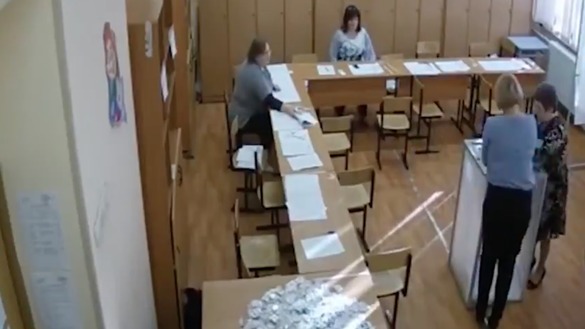 Видеотасвирдан олинган кадрда, 18 март куни Москвадаги сайлов участкасида икки нафар ишчи аёл сайлов қутисини сохта дея гумон қилинган бюллетенлар билан тўлдирмоқда.