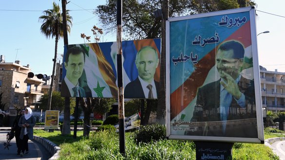 17 март куни олинган суратда Россия президенти Владимир Путин ва Сурия президенти Башар Асаднинг Алеппо шаҳридаги портретлари тасвирланган. (Жорж Урфалян/AFP)