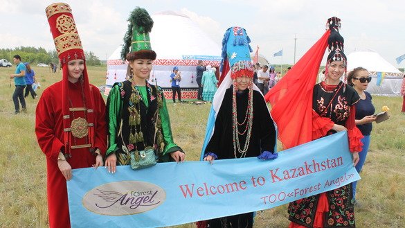 Female members of various nationalities welcome tourists to the festival. [Aydar Ashimov]