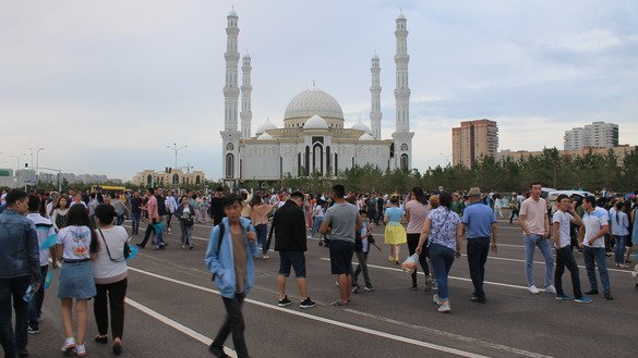Astana's central mosque is seen in the distance as scores of Kazakhs stroll down the street. [Aydar Ashimov]
