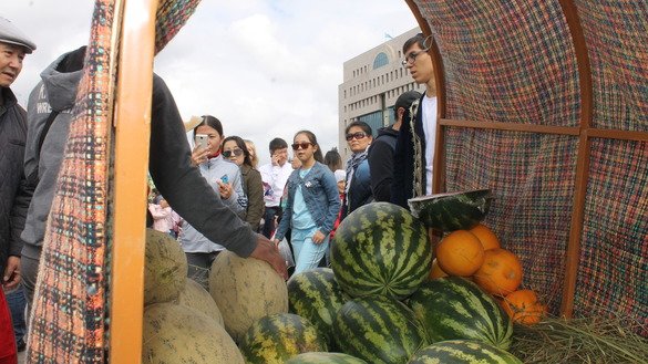 Посетители наслаждаются бесплатными образцами вкусных дынь из Ташкента. Некоторые покупают и забирают домой. Астана, 8 сентября. [Айдар Ашимов]