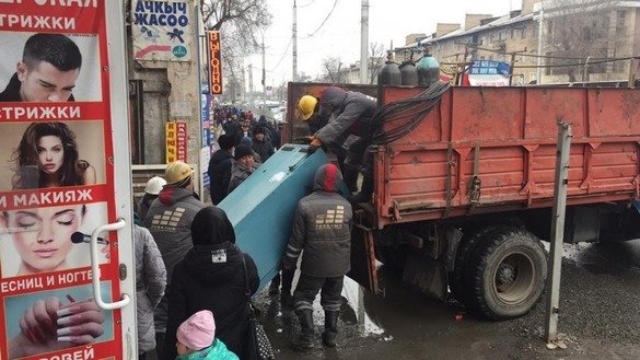 Bishkek city workers January 9 remove illegally dumped garbage from the Osh Bazaar, one of the capital's largest markets. [Bishkek City Hall]