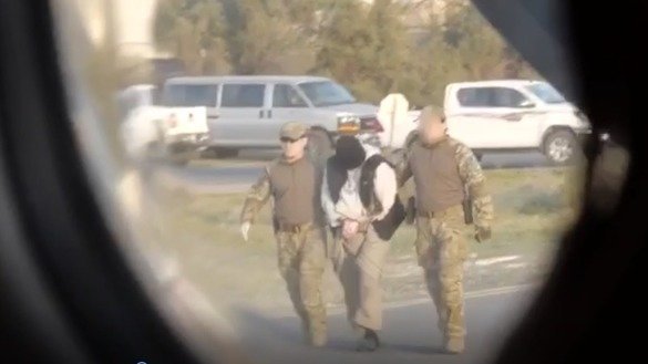 A video released by the KNB shows Kazakh men, blindfolded and handcuffed, being led to a plane in Syria during a January 5-6 repatriation operation. [Kazakh KNB]