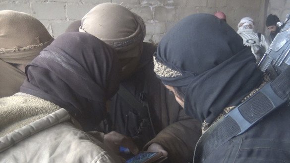 «Ислом давлати» (ИД) томонидан 13 декабрь куни Телеграм орқали тарқатилган суратда бир гуруҳ суриялик жангариларнинг смартфонга тикилиб тургани акс этган. (Файл)