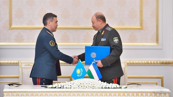 Kazakh Defence Minister Nurlan Yermekbayev and Uzbek Defence Minister Bakhodir Kurbanov exchange signed agreements on April 15 in Tashkent. [Uzbek Ministry of Defence]
