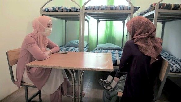 A psychologist (left) works with a Kazakh woman who returned from Syria at a rehabilitation centre in Mangystau Province, Kazakhstan. The screenshot is from a KNB video.