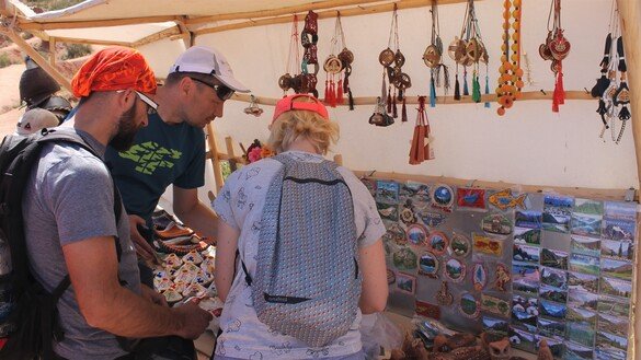 Гид-переводчик (посередине) показывает туристам из Франции сувениры, которые можно купить в местной лавке. Каньон «Сказка», 3 июля. [Айдар Ашимов]