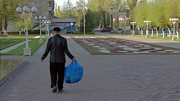 A man carries a bag with groceries in Taraz on April 18. Kazakhs are trying to stock up on food to avoid any unnecessary trips out of the house.  [Aydar Ashimov]