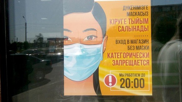 A sign on the window of a grocery store in Taraz, shown May 29, informs visitors that they must wear masks to enter. [Aydar Ashimov]
