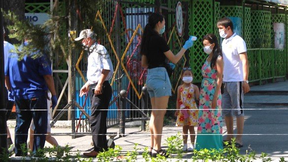 A woman checks visitors' temperatures at a city park in Taraz on June 1. [Aydar Ashimov]