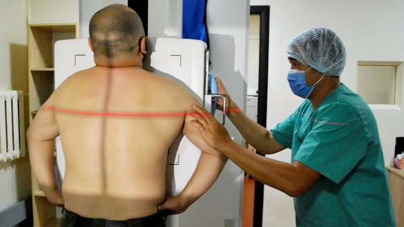 Kubanych Ashyrbekov, an X-ray technician at Centre for Family Medicine No. 2 in Bishkek, prepares a patient for an examination on August 14. [Maksat Osmonaliyev]