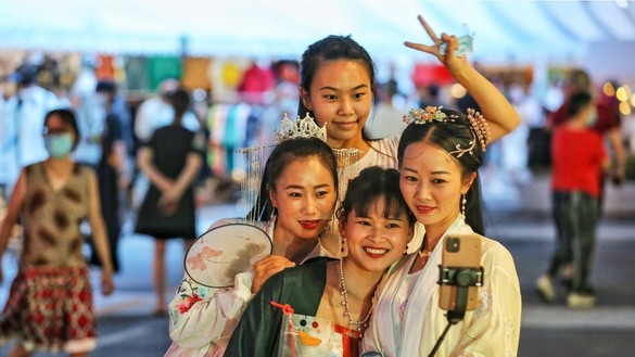 Женщины без средств защиты позируют для фото. Ухань, Китай, 27 августа. [STR/AFP]