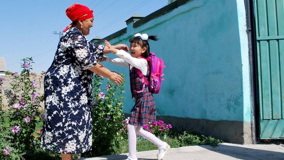 First-grader Ayyma Suyorbekova rushes into the arms of her grandmother to tell about her first impressions at school. Her grandmother is happy that her granddaughter has begun her studies. She agrees with the Ministry of Education's decision to have first-graders learn in classrooms rather than at home. "At this stage, the foundation for knowledge is laid and only teachers will be capable of providing a good education," she said. September 1, K. Ibraimaliyev School, Kurpuldok village, Panfilov District, Chui Province. [Maksat Osmonaliyev]