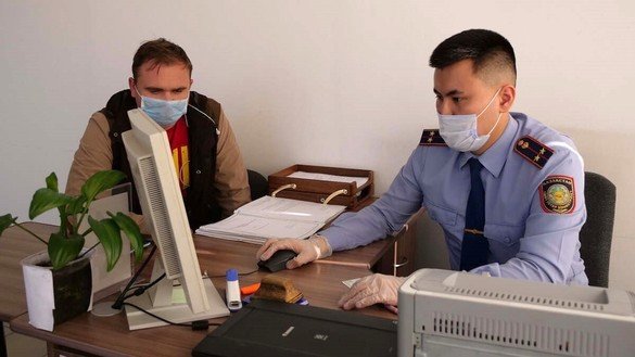Migratsiya politsiyasi xodimi fuqarodan maʼlumot olmoqda, 25-avgust, Qozogʻistonning Petropavlovsk shahri. (IIV)