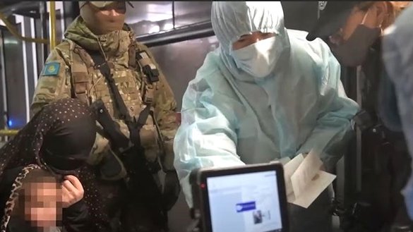 Казахстанские специалисты допрашивают женщину с ребенком, возвращенную из Сирии в рамках операции «Жусан-5». Кадр из видео, размещенного на YouTube КНБ Казахстана.